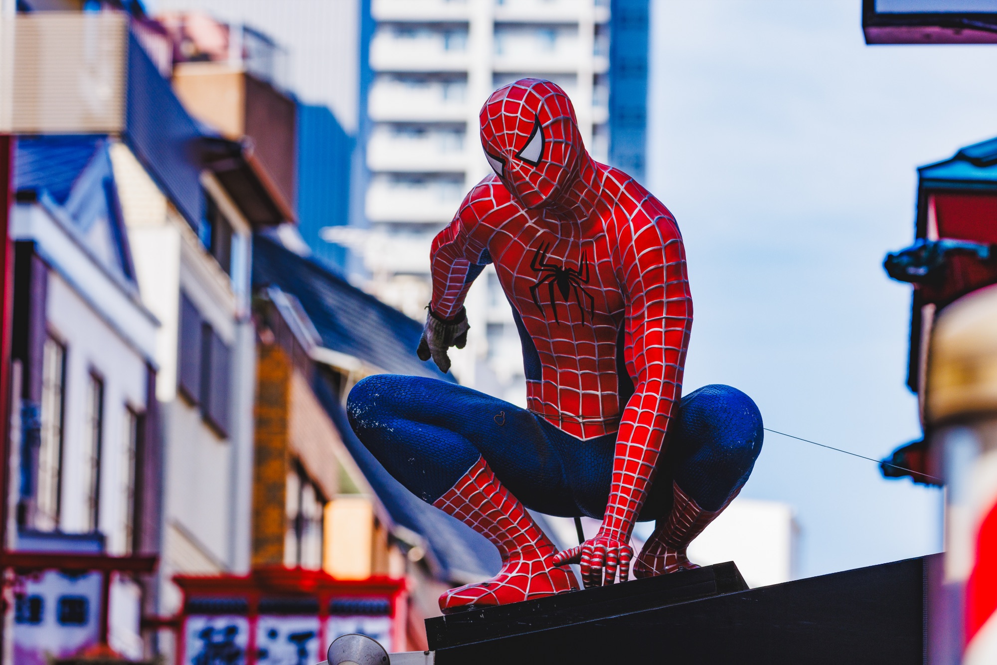 神戸の南京町で建物の上に座っているスパイダーマンの像