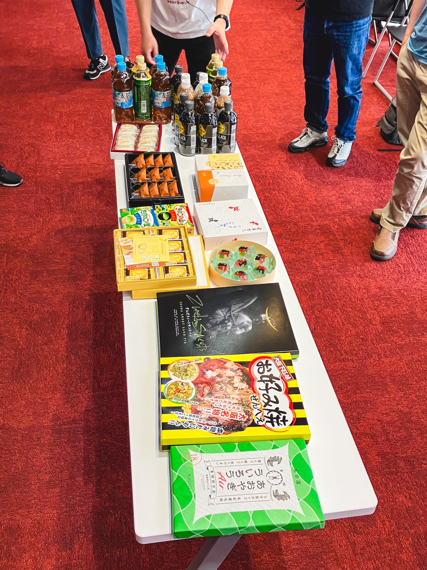 勉強会の長いテーブルに各地のお菓子と飲み物が並んでいる様子