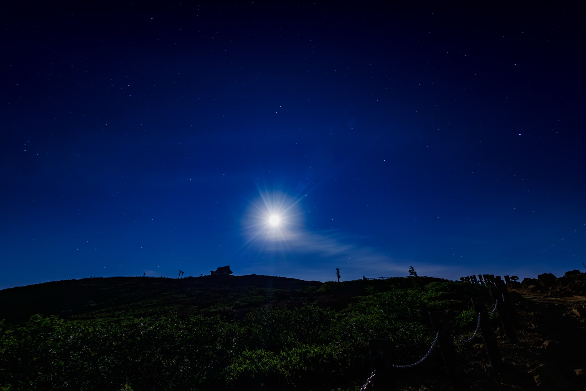 蔵王の稜線から昇る明るい月と星空