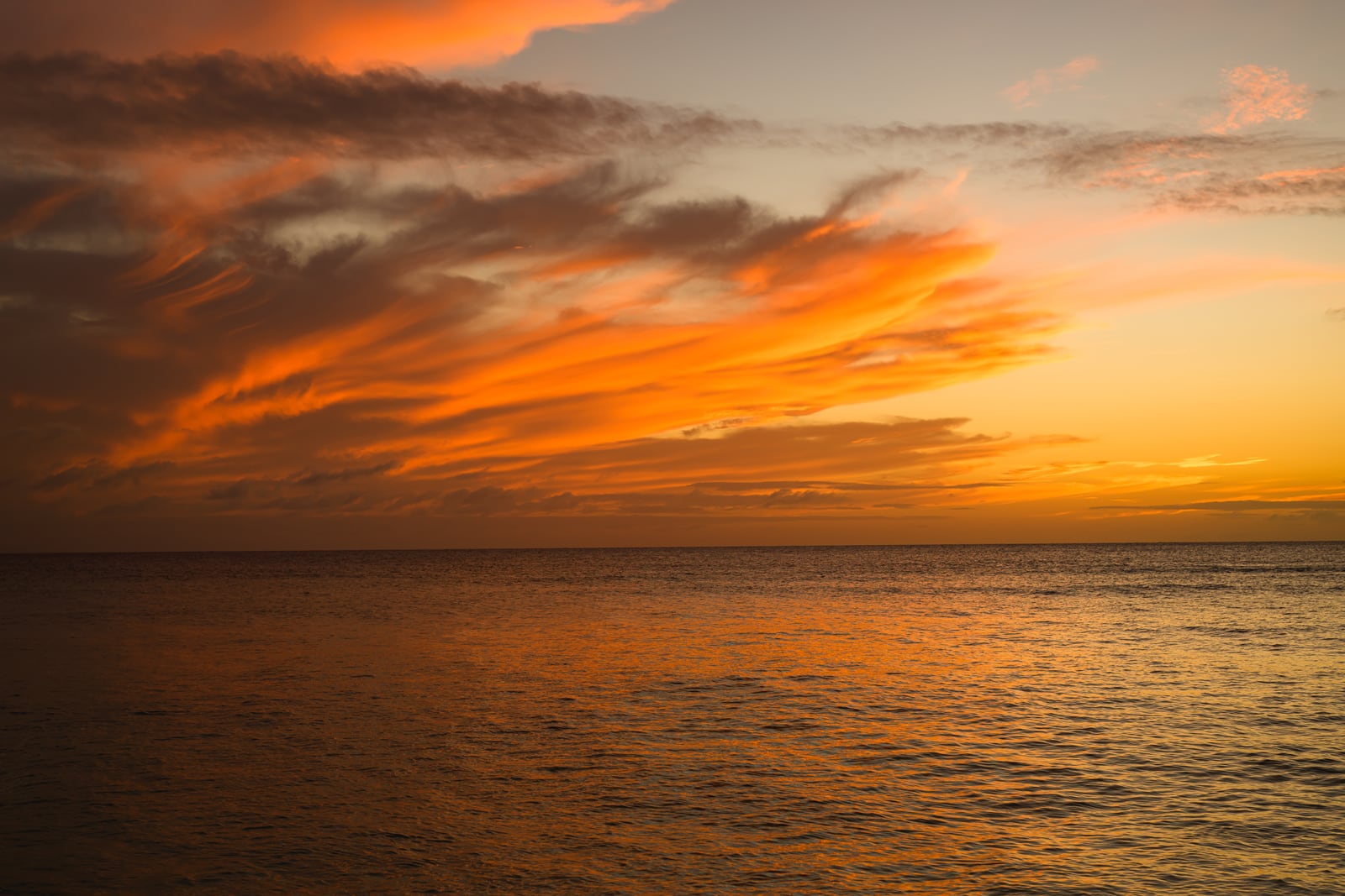与論島の海をオレンジ色に染める夕焼け雲