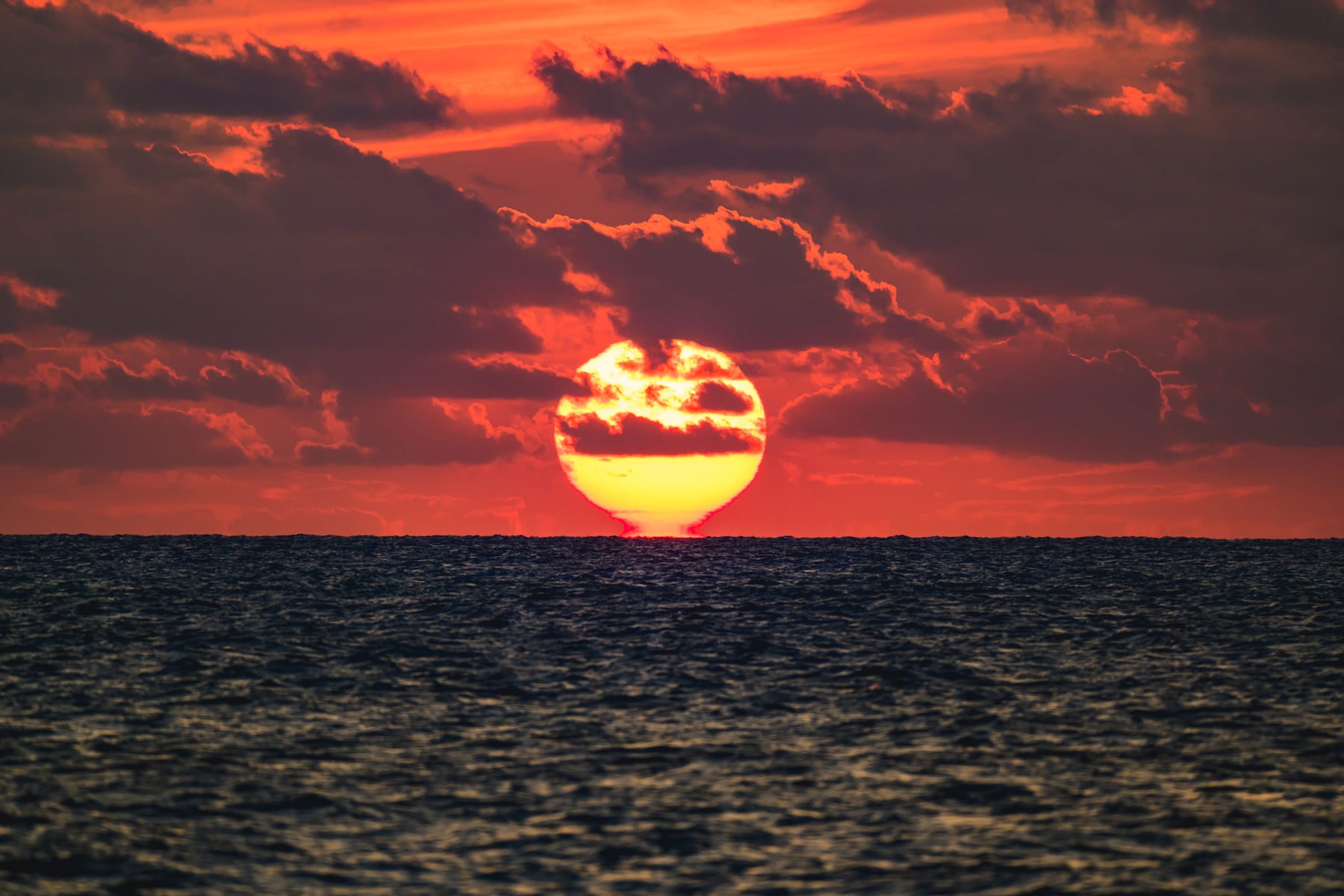 来間島のムスヌン浜から見た赤く染まり海へ沈む夕日