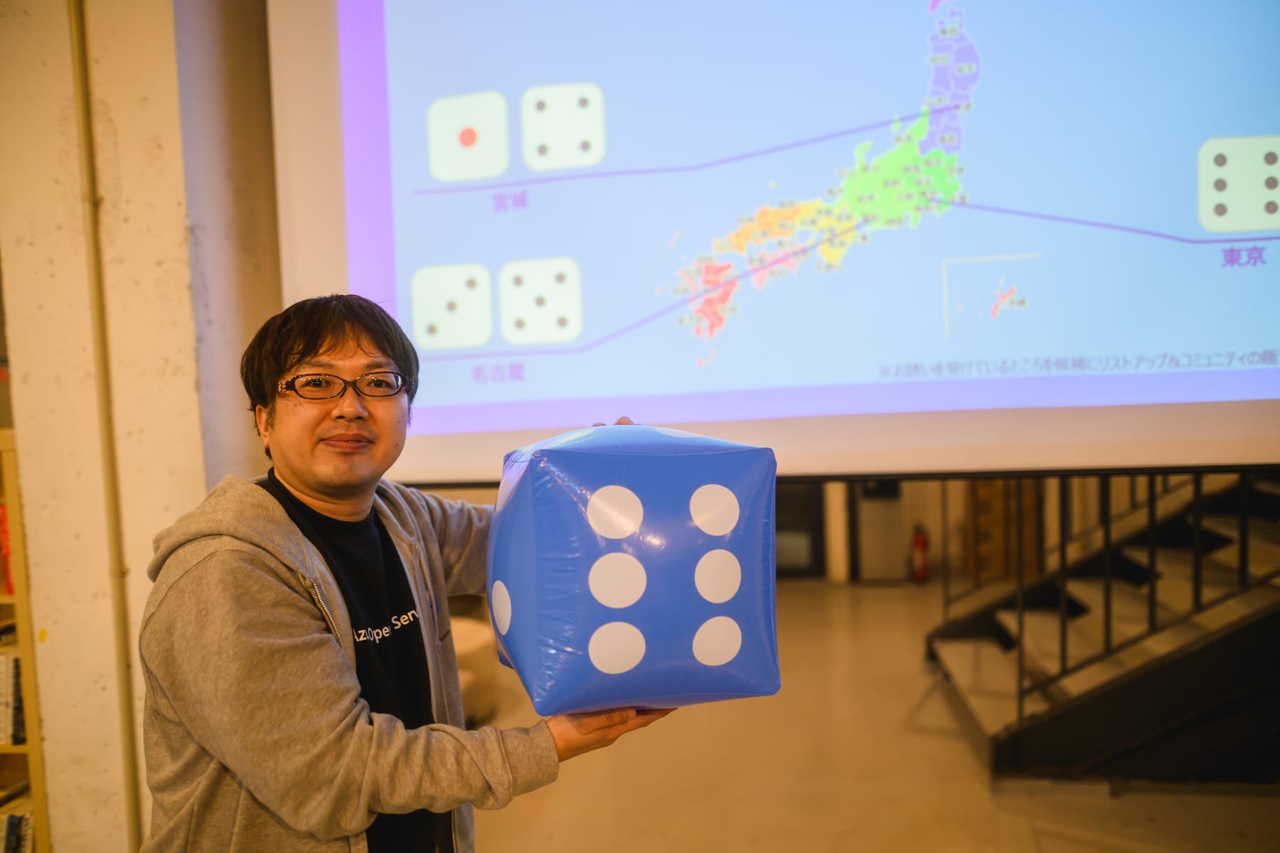 大きな青いサイコロを持ち東京開催の決定を伝えるAzure Travelersの運営メンバー
