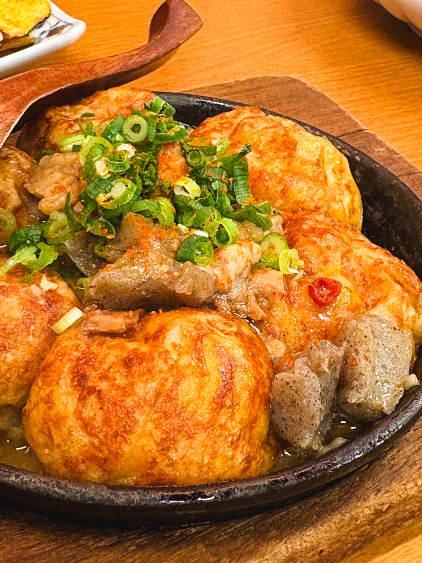 濃い色のみそだれがかかったたこ焼き風の料理