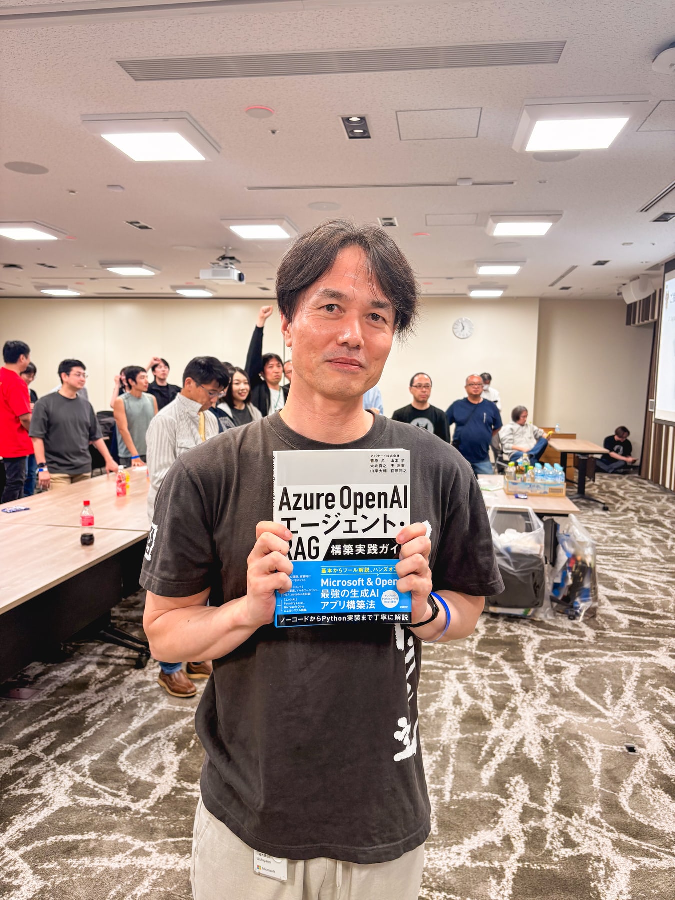 懇親会でAzure OpenAIデザインパターンの本を手にする牛神様