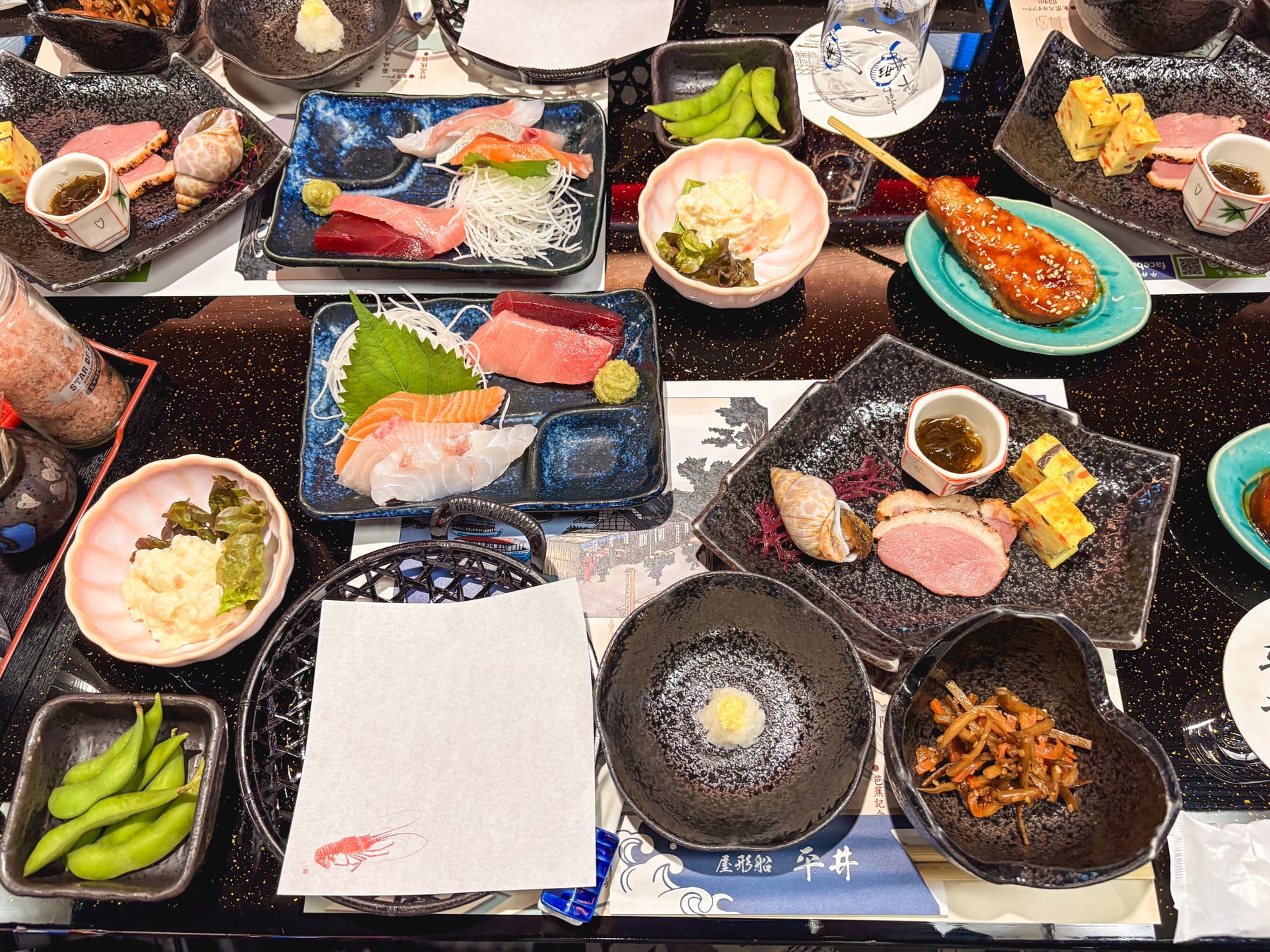 刺身や天ぷら、枝豆などがテーブルいっぱいに並んだ屋形船の料理