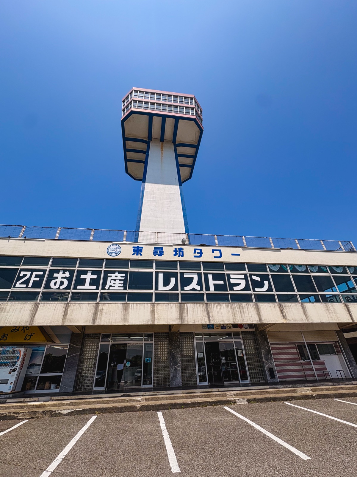 青空の下に立つ年季の入った東尋坊タワー