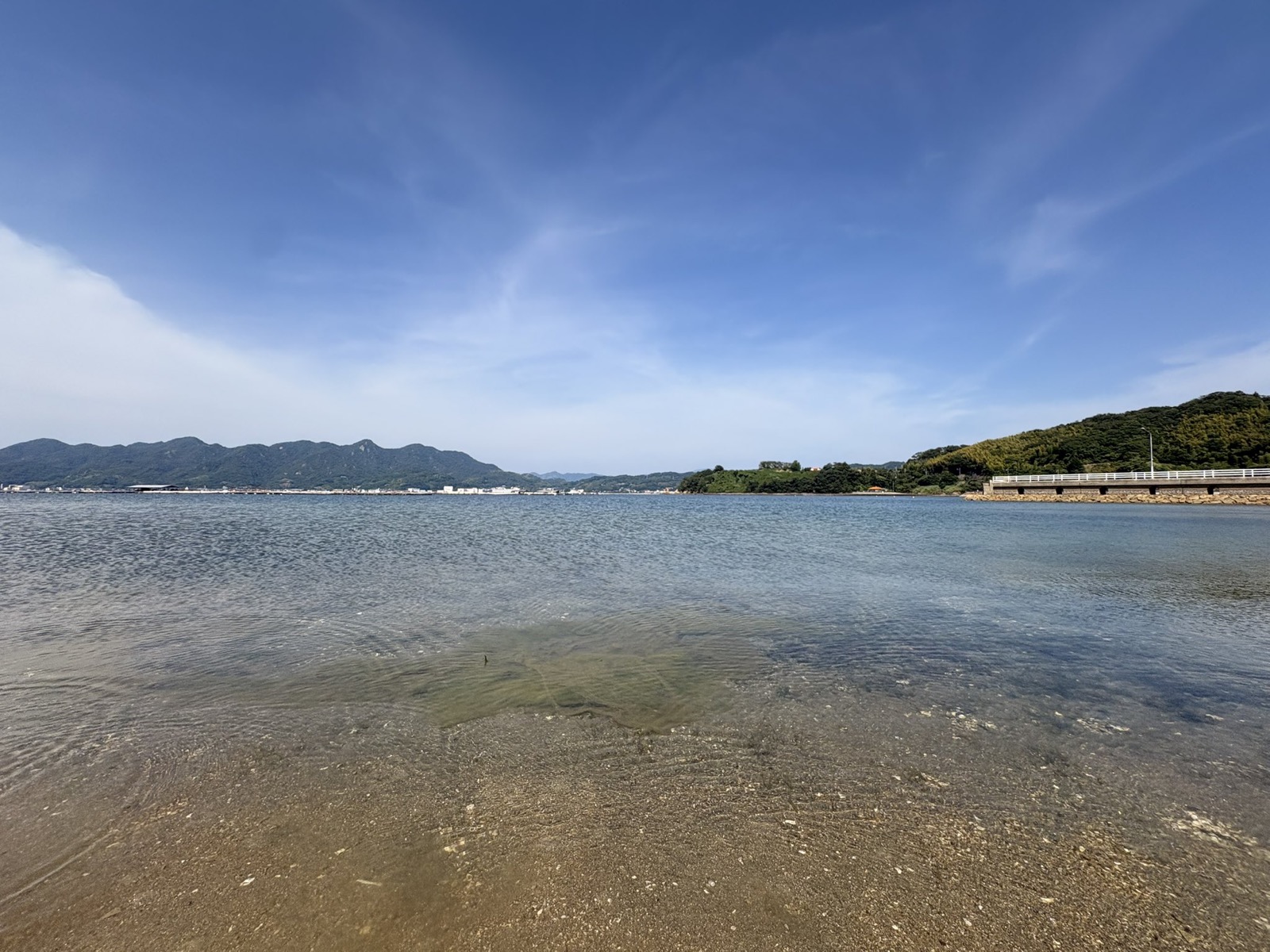 干潮時のヒューマンビーチ長瀬から見た透明な海と対岸の山