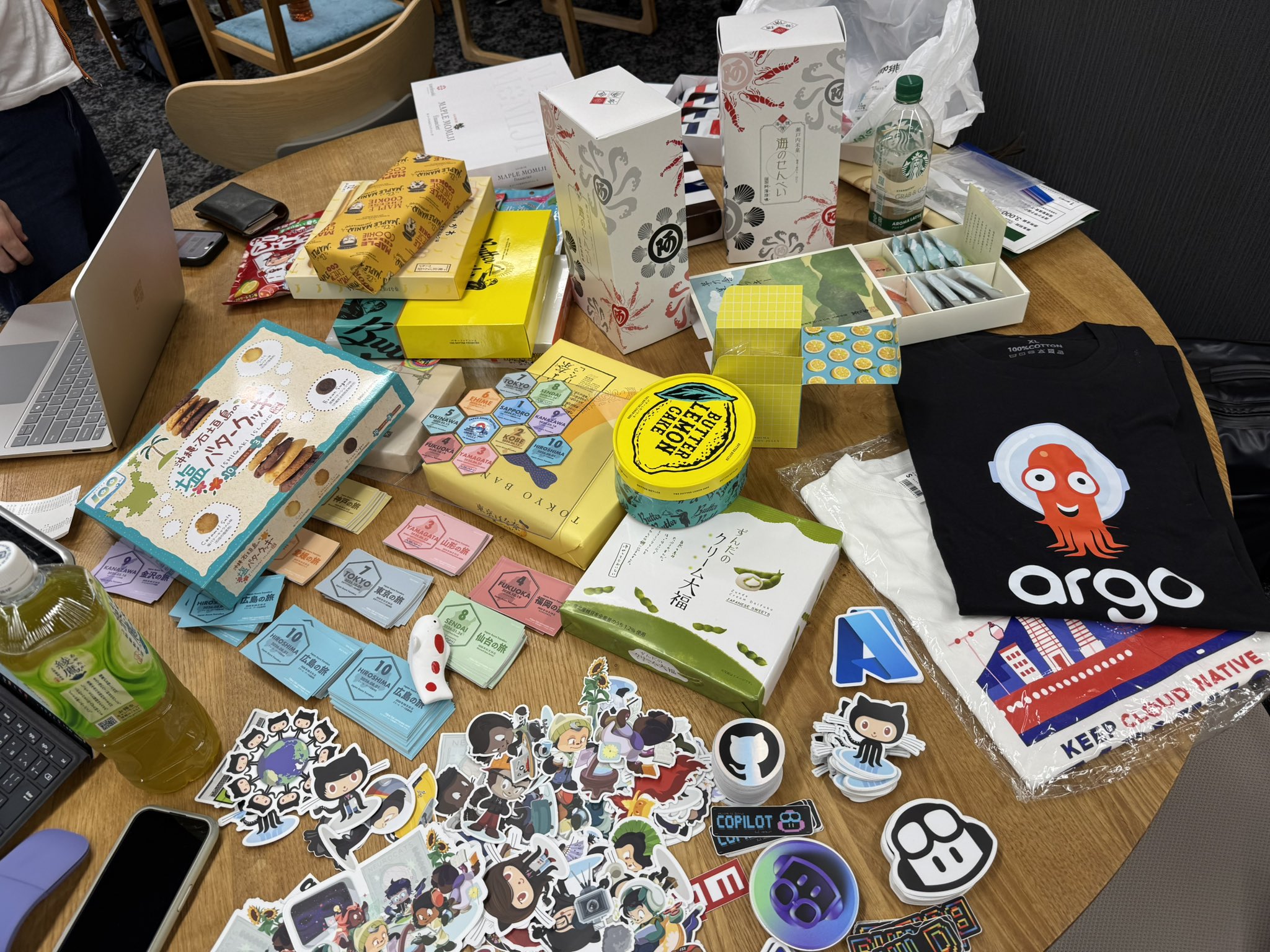 各地のお土産とコミュニティグッズが並んだテーブル