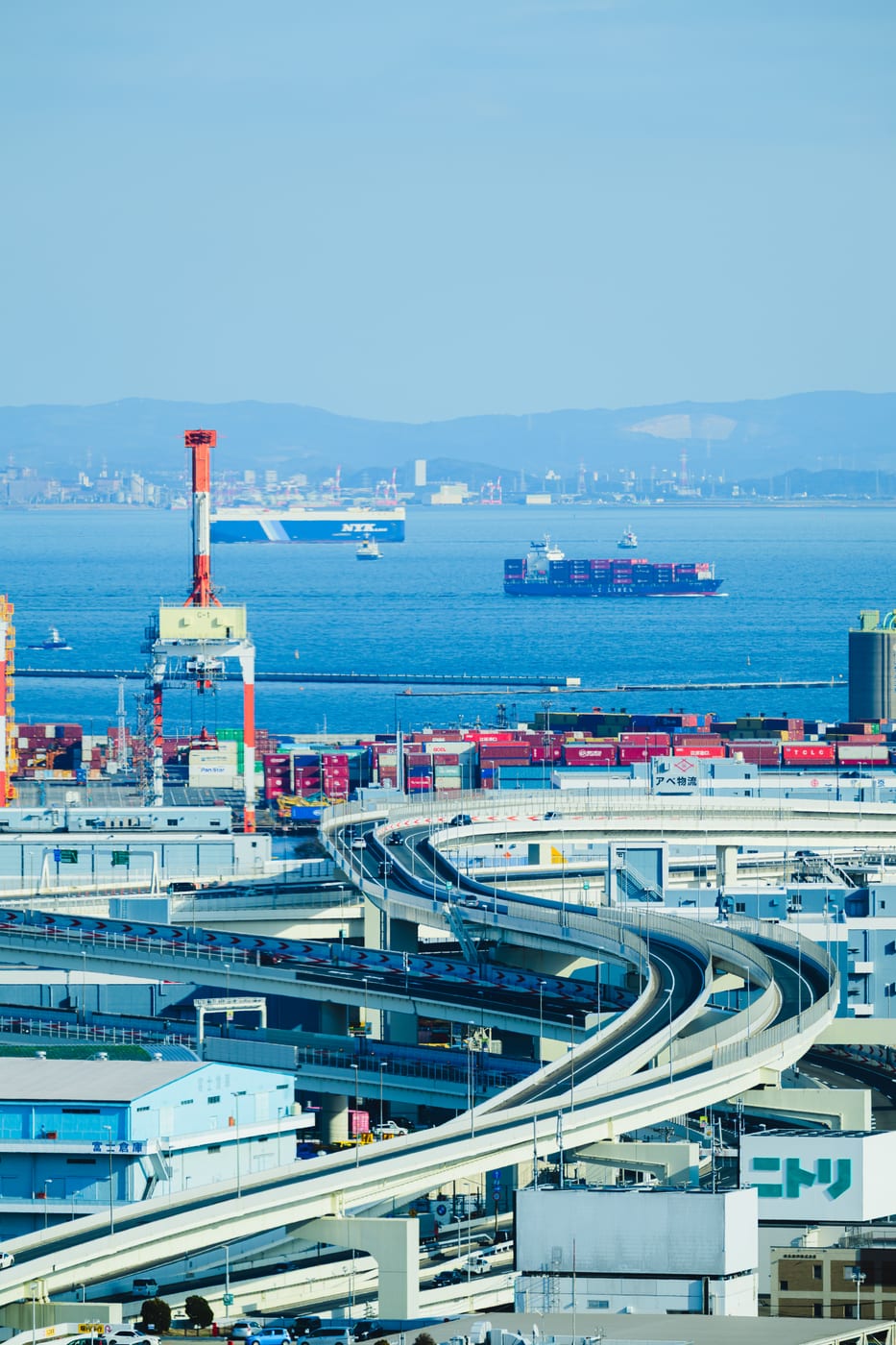 Curving elevated roadway above Yokohama Port with a cargo ship
