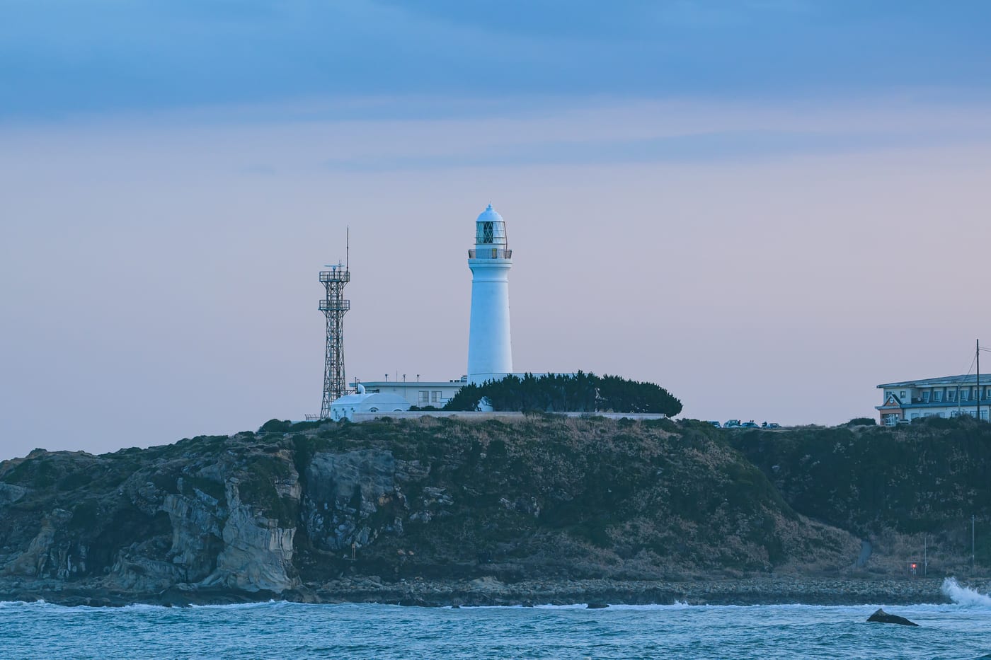 The white Inubosaki Lighthouse standing on the coast at dusk
