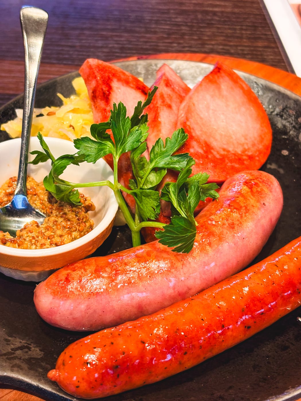 Three kinds of sausages served with side vegetables