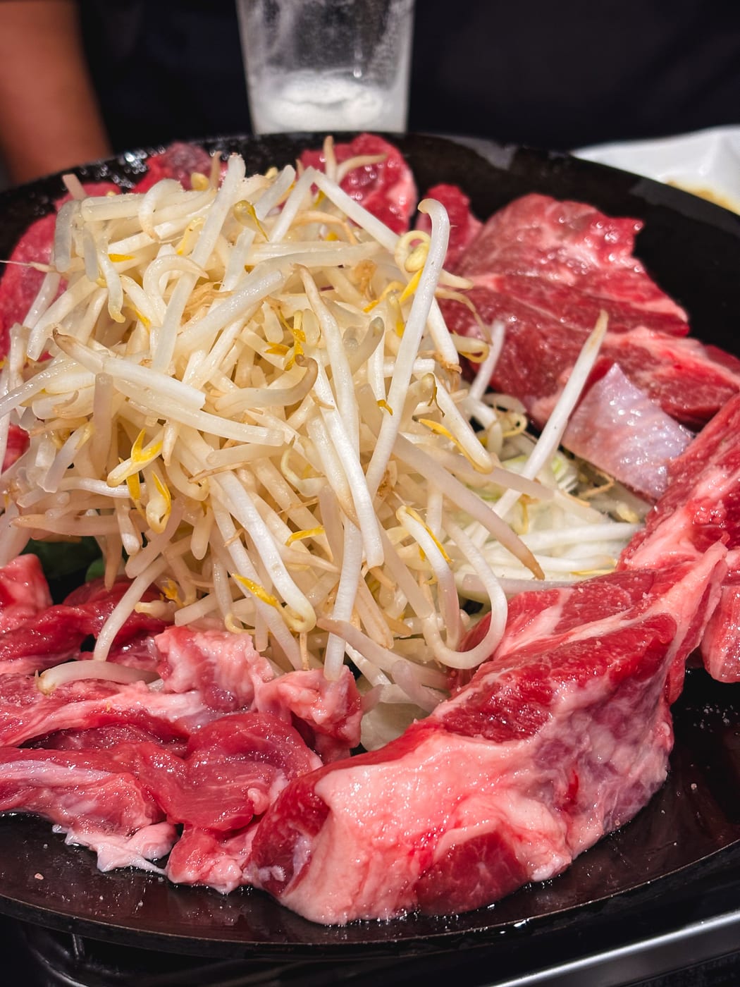 Jingisukan grilling in a pan with onions and bean sprouts