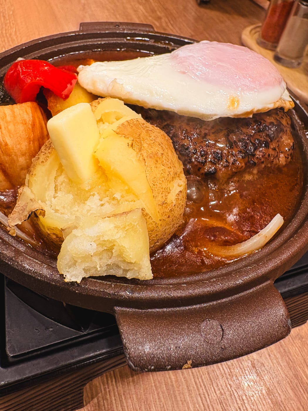 A skillet dish with a fried egg, potatoes, and bell peppers