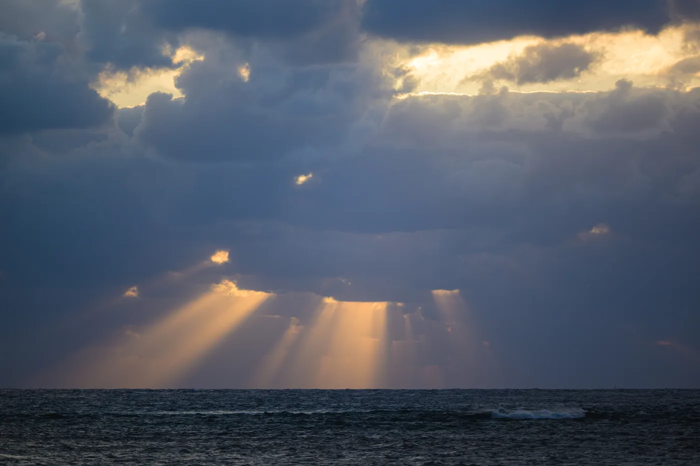 Light falling on the sea through breaks in thick clouds