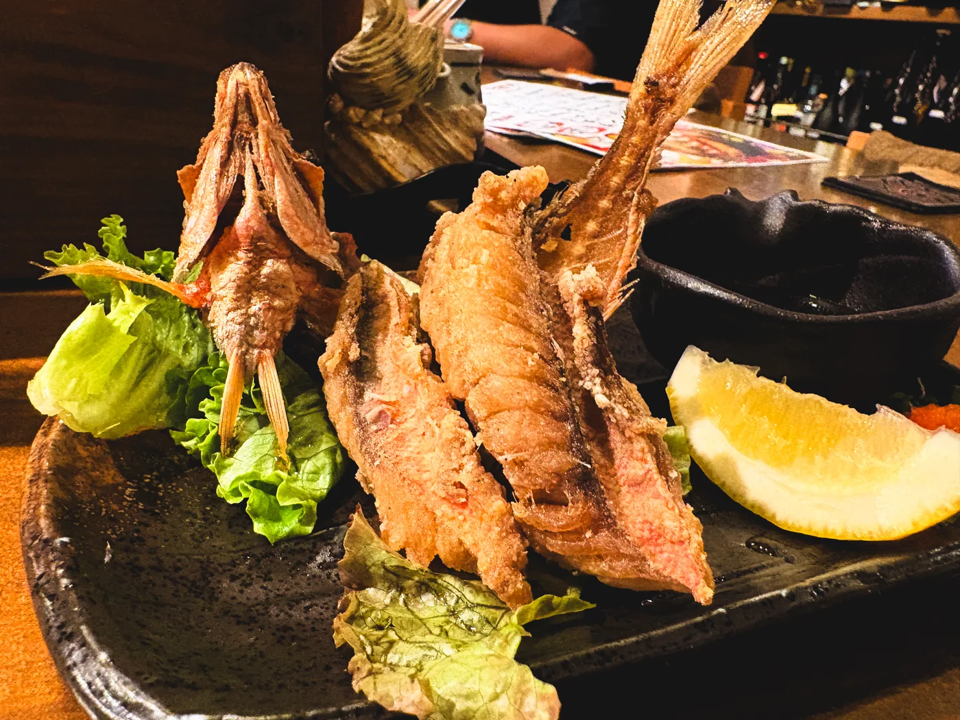Fried gurukun served with lemon