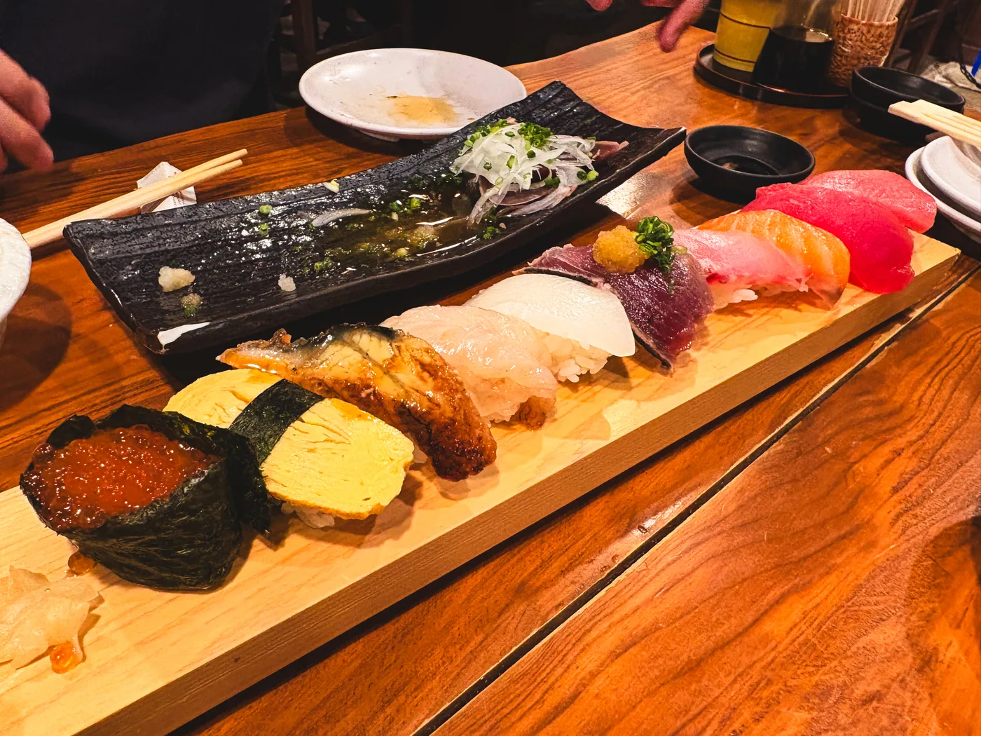 Nigiri and gunkan sushi arranged on a wooden board