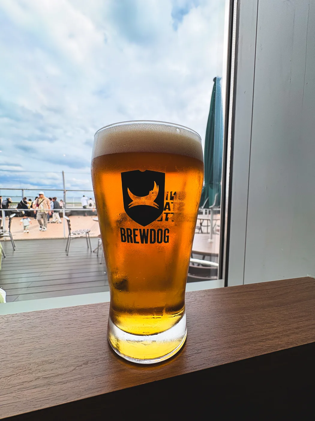 A glass of Punk IPA beside a window at Haneda Airport