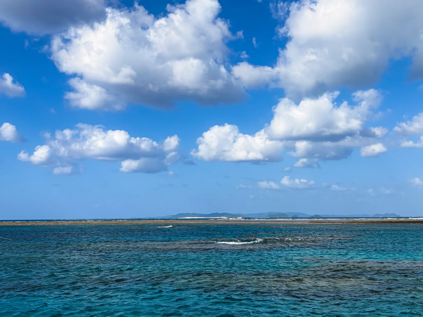 Shallow water near Kamiyama Island with clouds along the horizon
