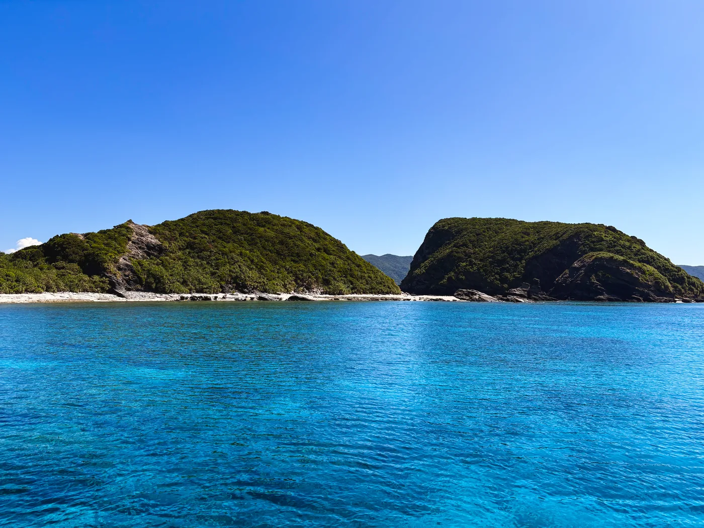 Blue water beside a green island near Kerama