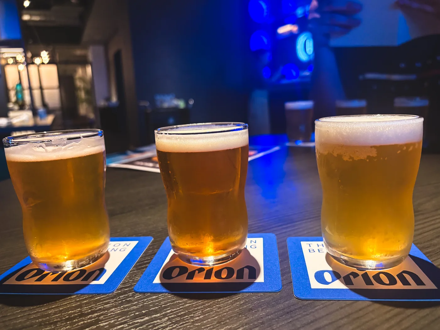 Three beers lined up on Orion coasters