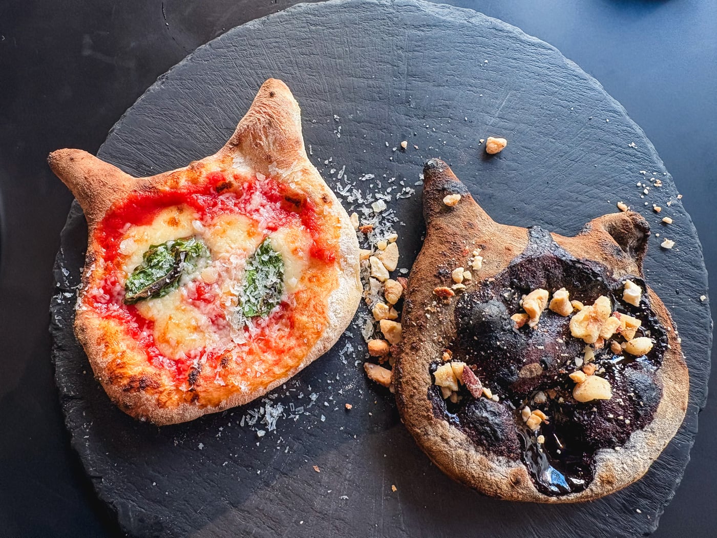 Cat Day special pizza shaped like a cat's face with different toppings on each side