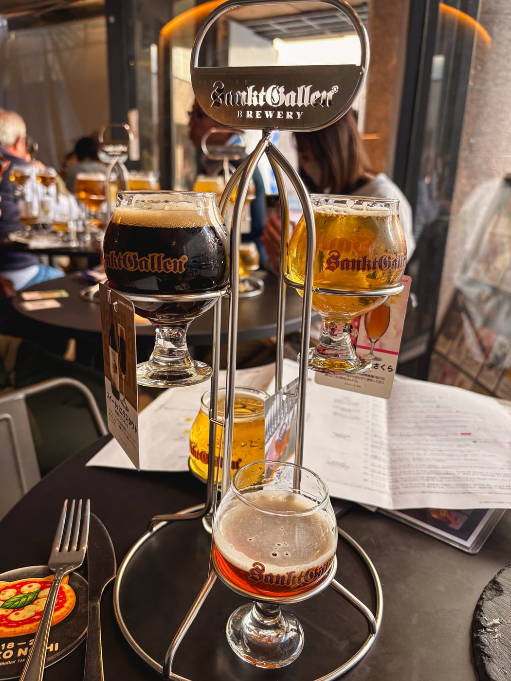 Four Sankt Gallen beers lined up in a tasting flight stand