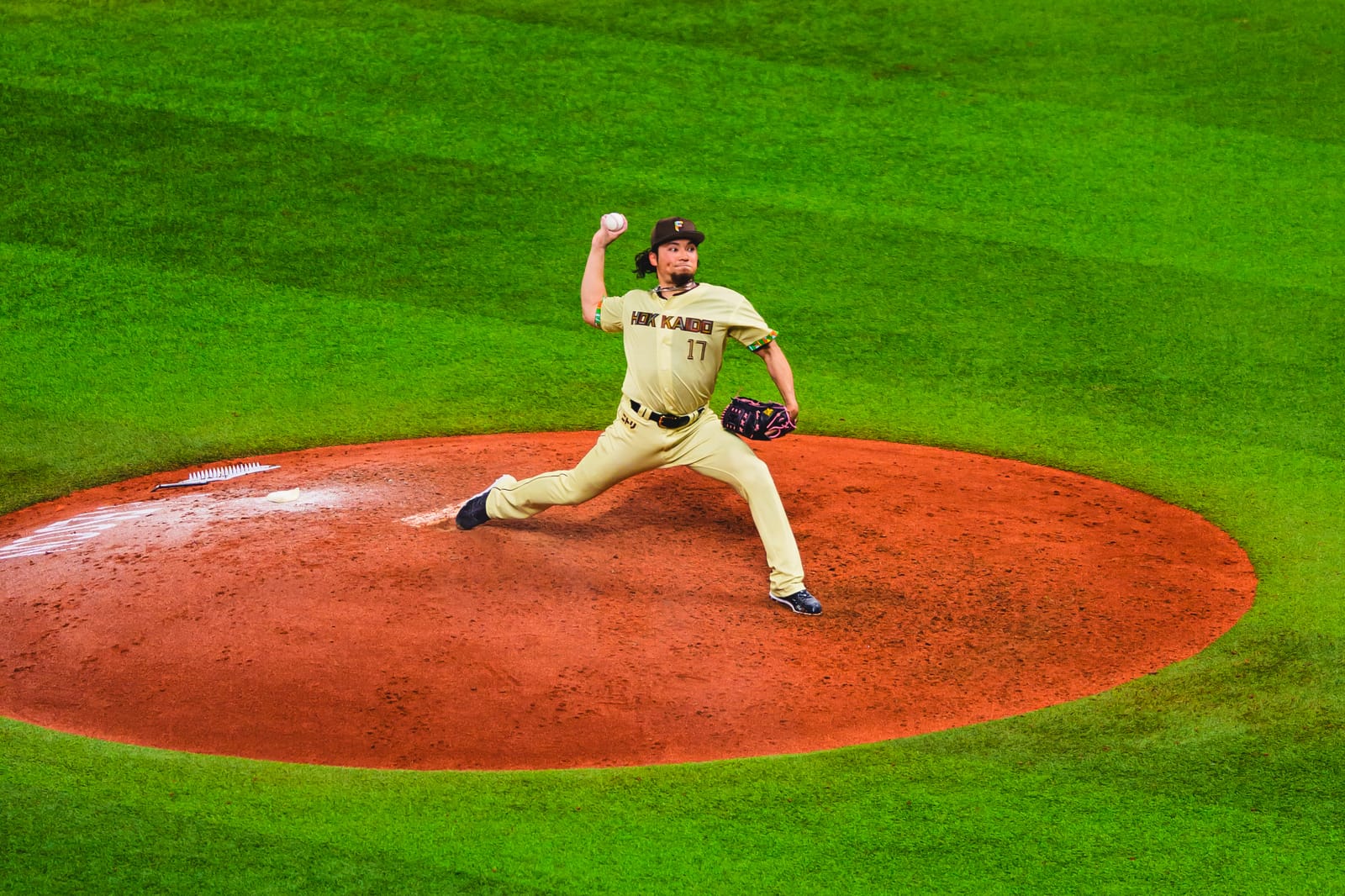 Hiromi Ito delivering a powerful pitch from the mound at ES CON FIELD HOKKAIDO