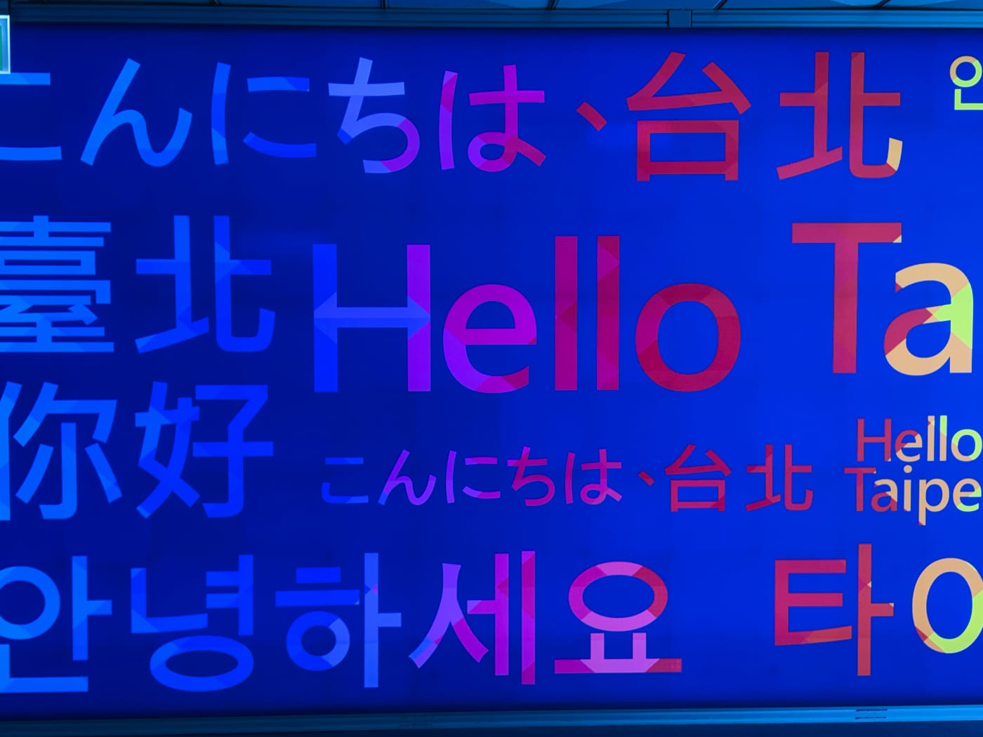 A multilingual welcome message displayed at Taipei Songshan Airport