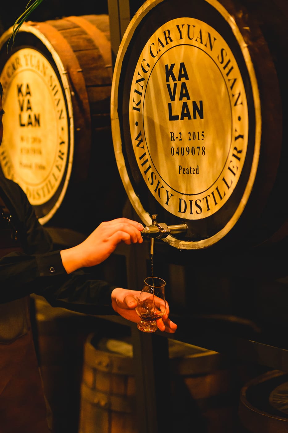 A staff member pouring whisky from a cask at KAVALAN WHISKY BAR