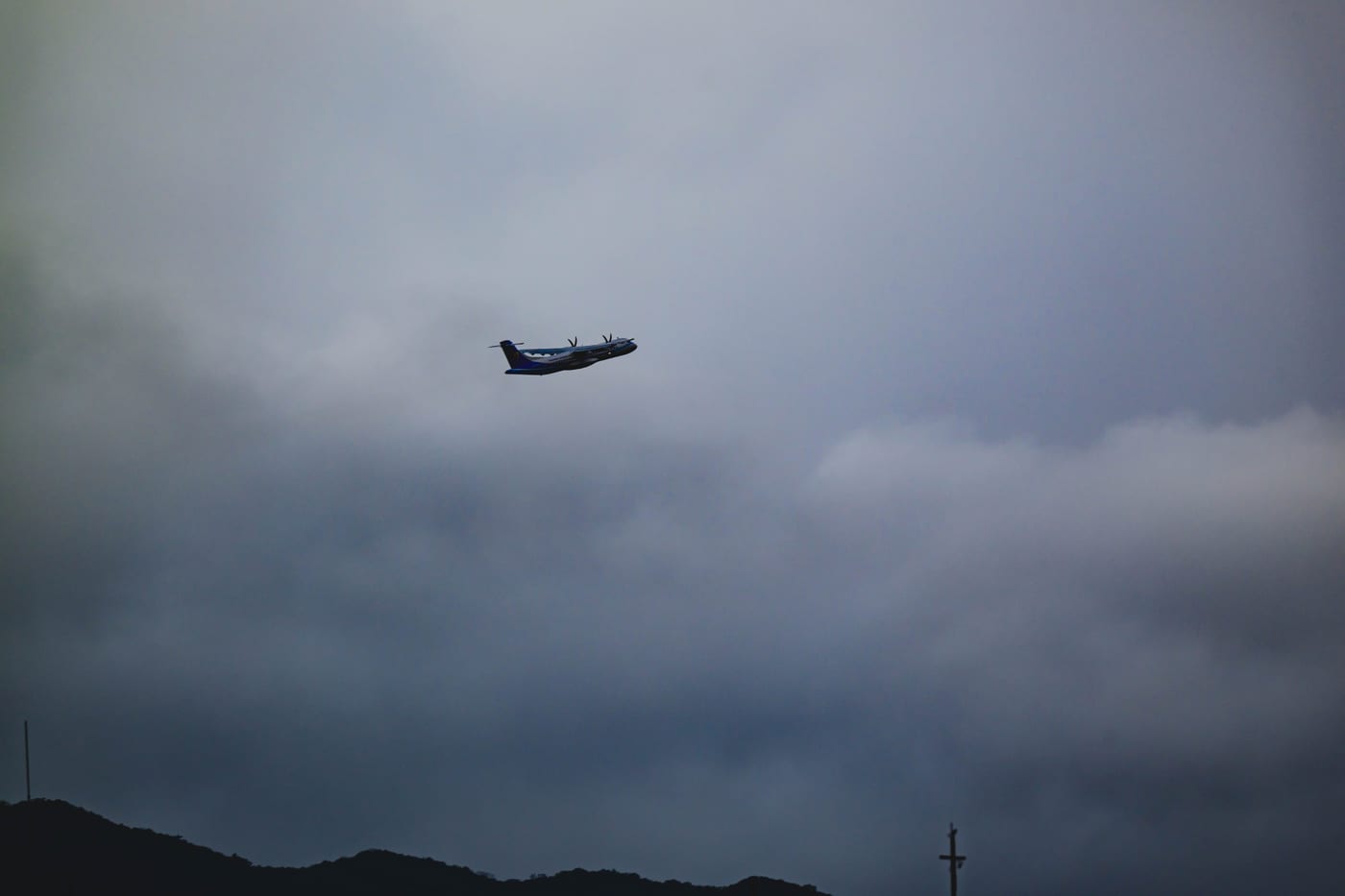 An airplane flying through Taipei's cloudy morning sky