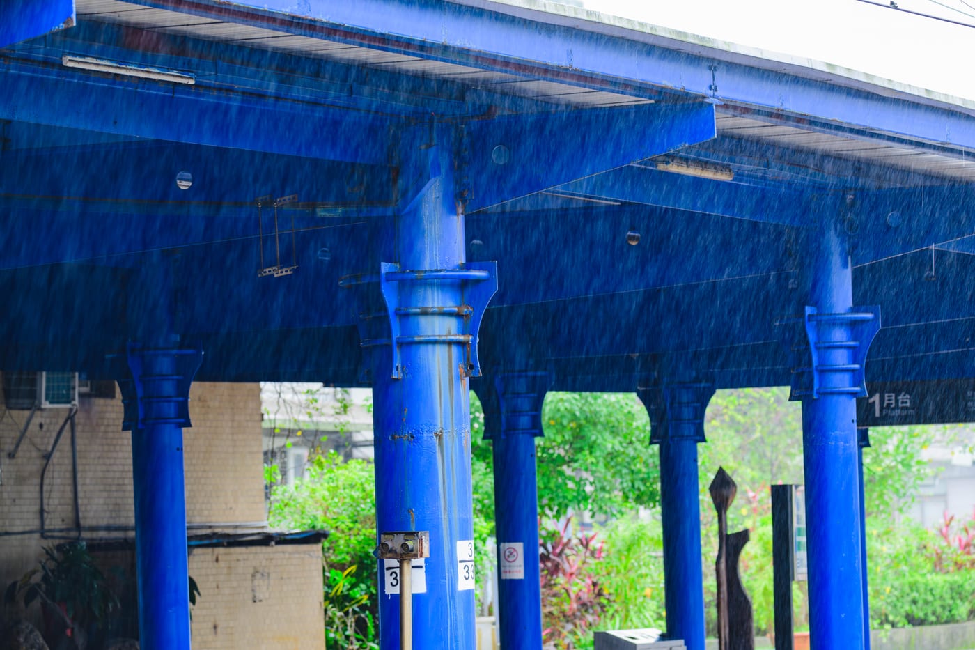 A rain-soaked elevated roadway in Taipei with blue columns