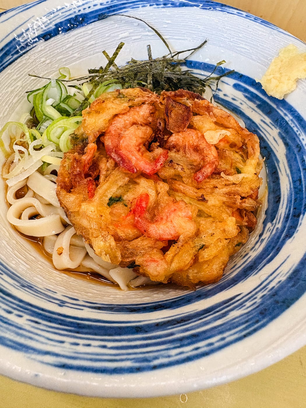 A breakfast of cold kishimen topped with a large kakiage fritter