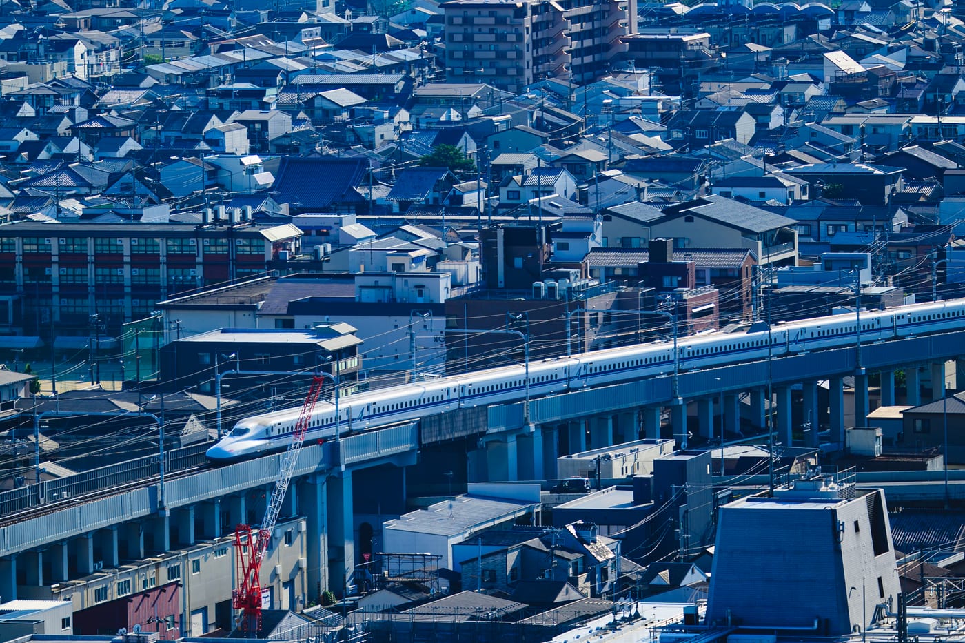A white Shinkansen train running through Kyoto