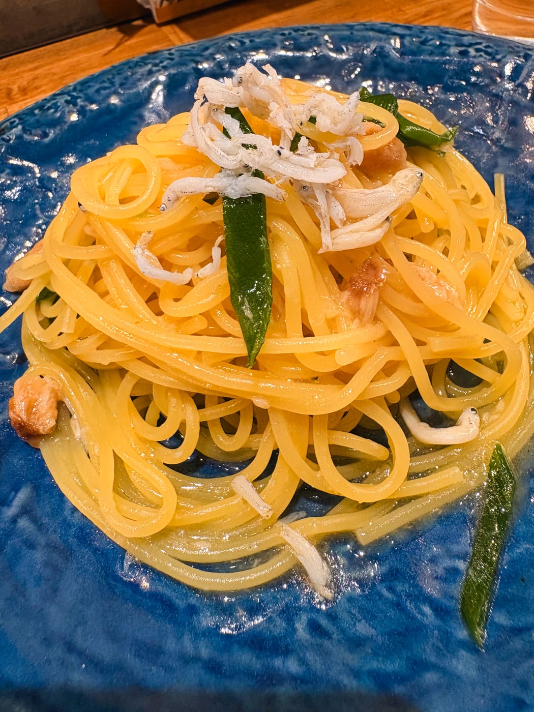 Pasta with an oil-based sauce served on a blue plate