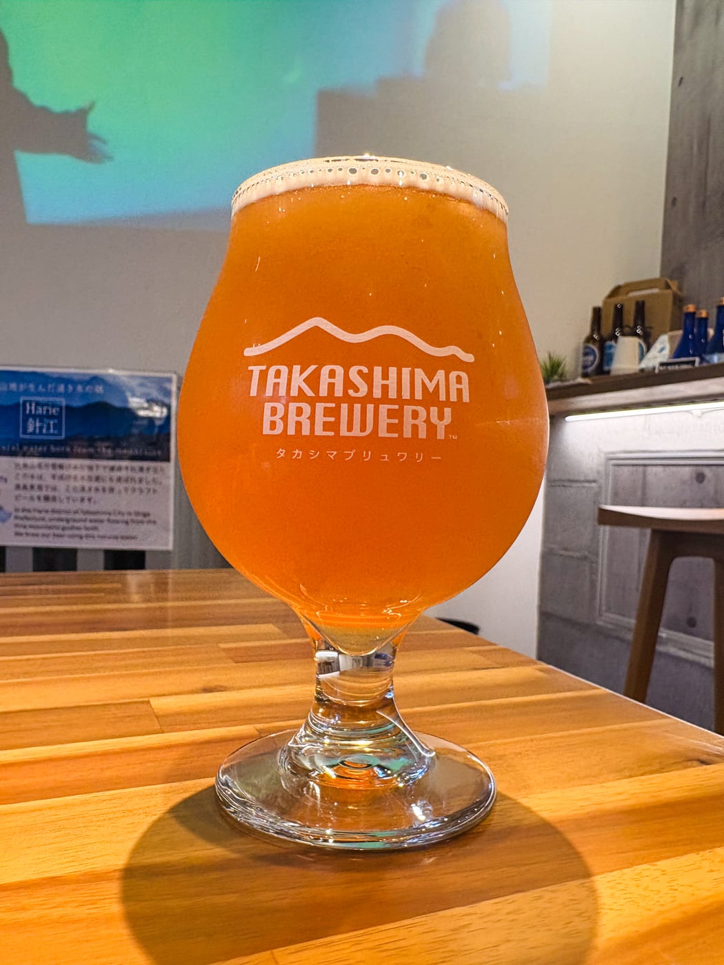 Craft beer poured into a glass with the Takashima Bakushu logo