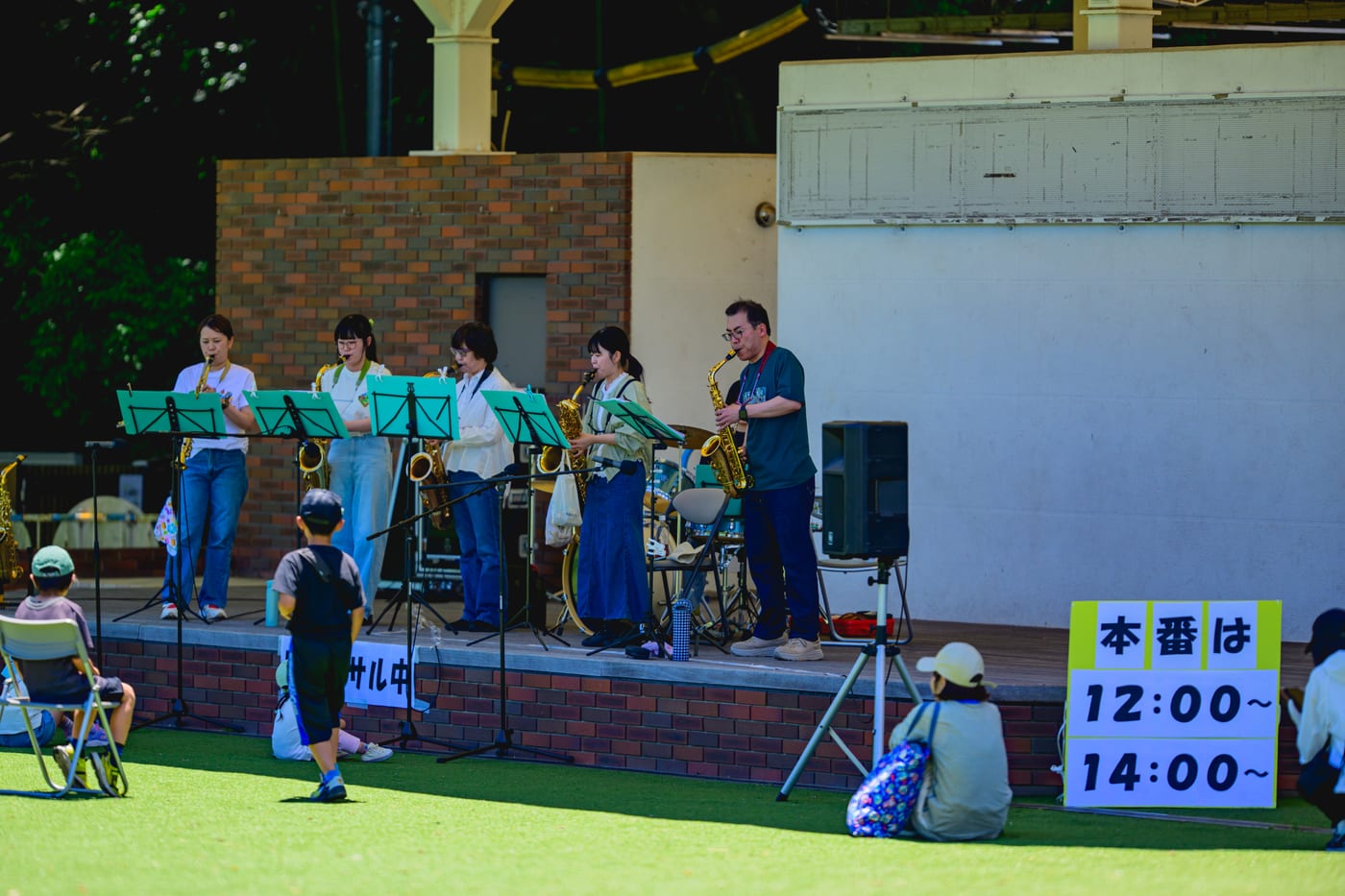 A brass band rehearsing with saxophones on a stage in 138 Tower Park