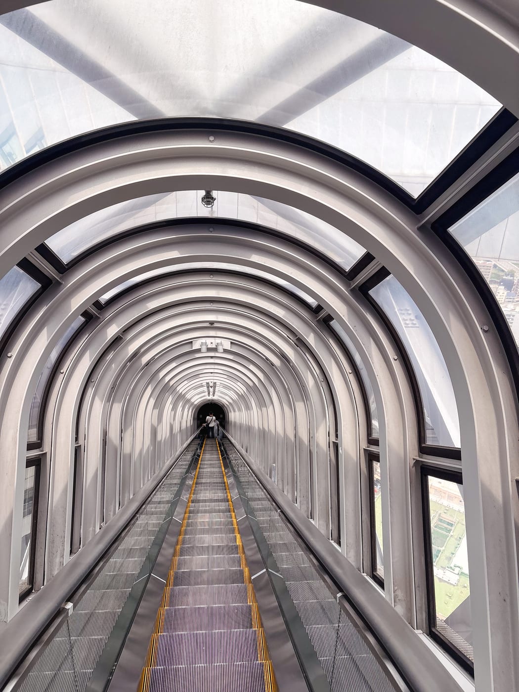The long escalator at Umeda Sky Building inside a glowing circular tunnel-like space