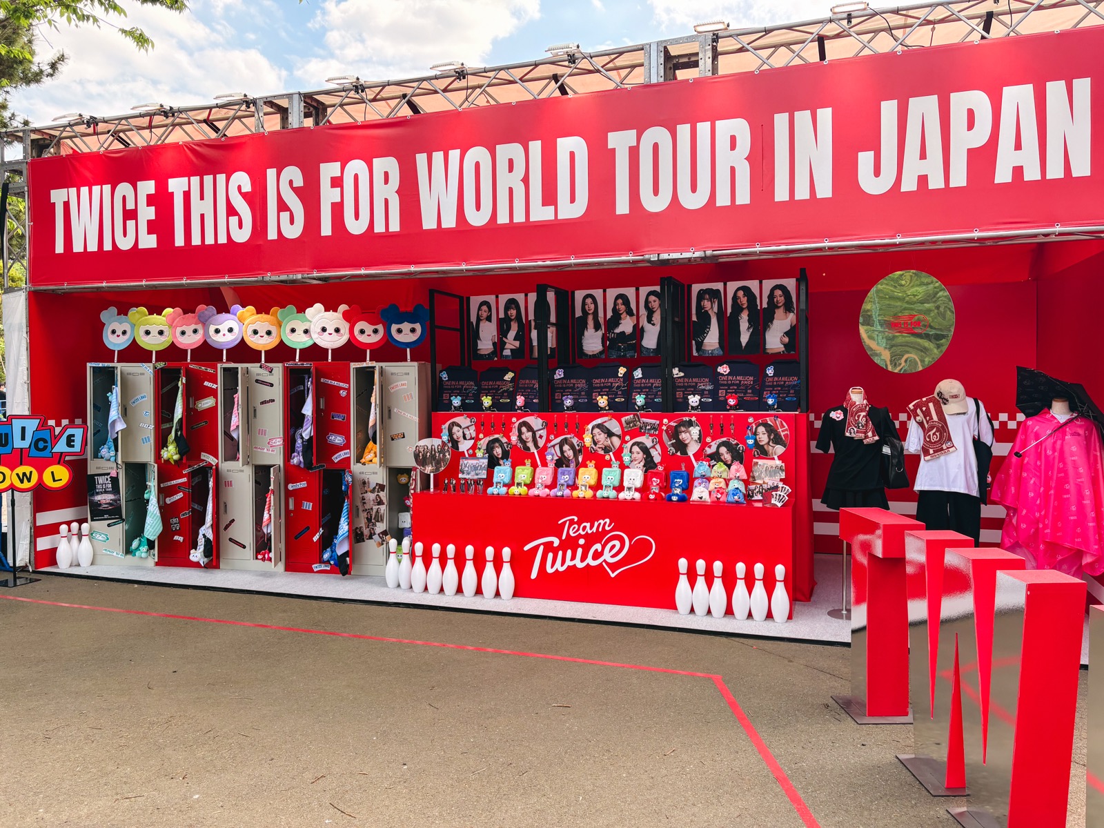 Display outside the venue with TWICE member photos, character goods, and other merch from this concert