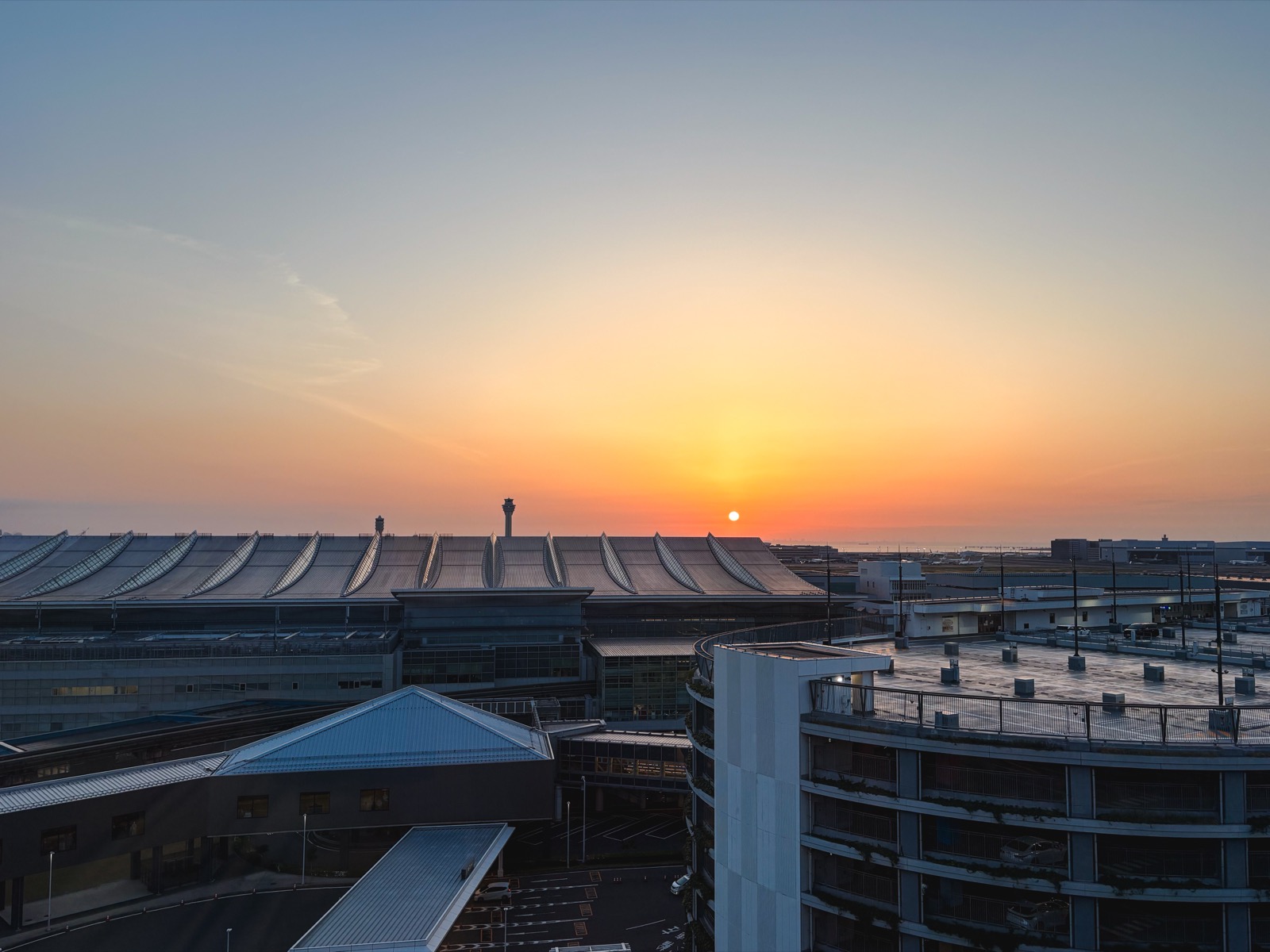 The morning sun rising from behind the buildings at Haneda Airport