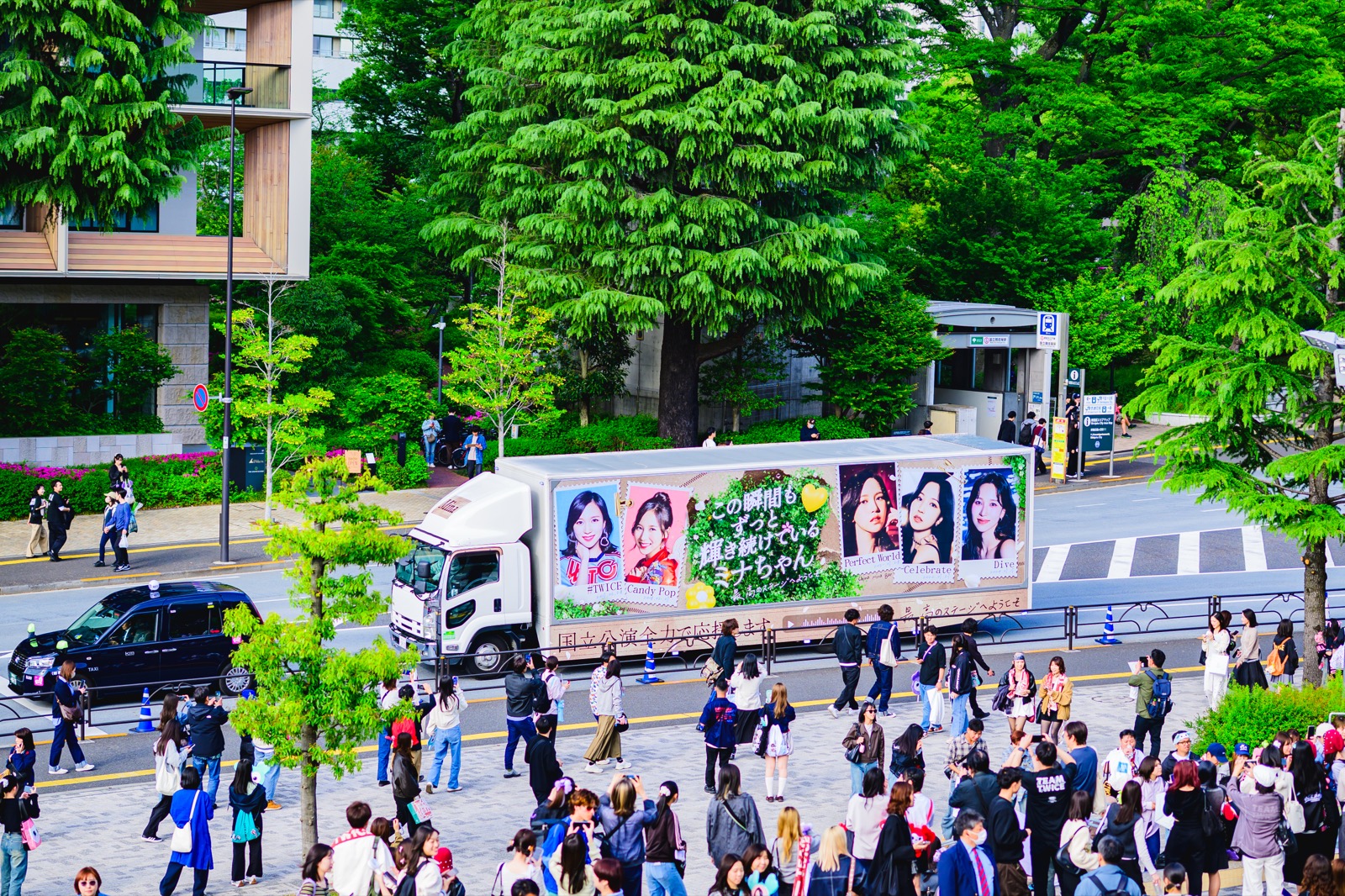 Support wrapping truck decorated with photos of MINA driving past National Stadium