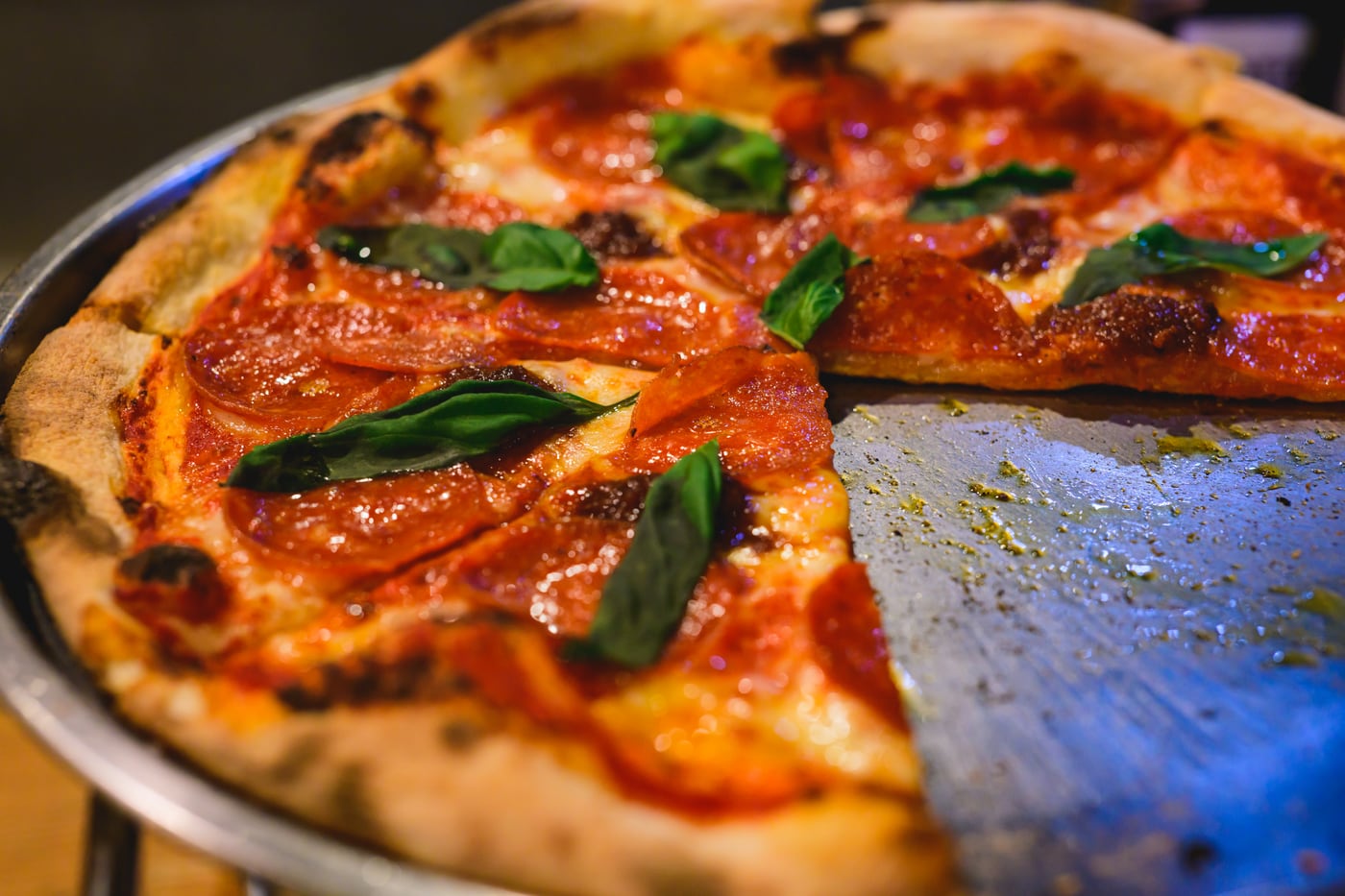 Freshly baked pizza topped with tomato sauce and basil